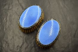 A pair of George V silver and guilloche enamel clothes brushes, of oval form having blue guilloche