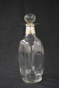 A Victorian silver mounted decanter, of canted form having a silver flared floral motif rim and neck