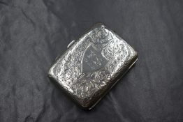 A George V silver cigarette case, of hinged rectangular form having scroll decoration with a central