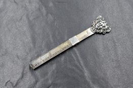 A 20th century silver hem gauge ruler, having an Art Nouveau style maiden to the head with a three