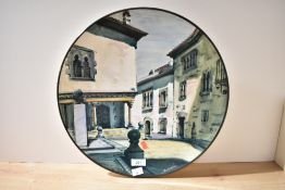 A large vintage ceramic decorative plate depicting a Mediterranean village scene 40cm diameter.