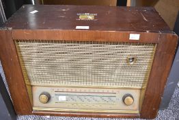 A mid 20th-century HMV Model 1251 valve radio, having a veneered wood cabinet, gilded trim and a '