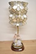 A Leonardo figurine lamp 'Sunday Best' sold along with a white Capiz lotus flower lampshade.
