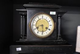 A 19th-century black 8-day mantel clock, having black Roman numerals on an enamelled chapter ring,