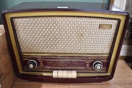 A Vintage Stella bakelite cased radio with woven material speaker grille and glass tuning scale with