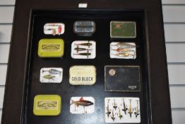 A Display of tobacco tins containing fishing lures with quill minnows, toby's and other vintage