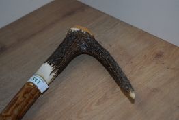 A large walking stick with antler handle measuring 134 cm long and bearing transfer images of a