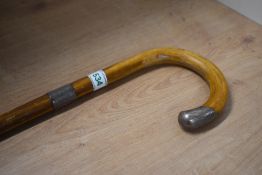 A short walking cane with silver band and a silver tip to handle measuring 82cm long