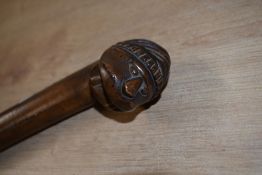 A broad shafted antique walking cane made from Olive wood with a mans face as the handle and the
