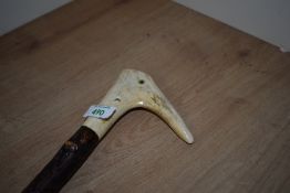 A twisted wooden walking stick with an antler top and an eye having being added to give the