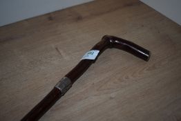 A hazel walking stick measuring 90 cm long with rubber foot and a silver ferule inscribed 'W. Wright