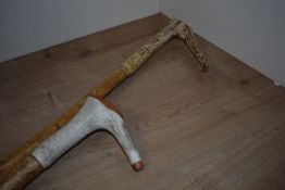 Two long walking sticks with antler handles measuring 118cm and 143cm