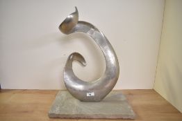 An unusual contemporary metal sculpture, of a free abstract form and having a heavy stone base,