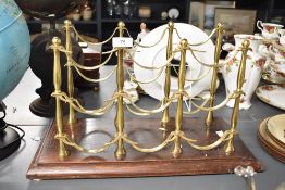 An early 20th-century French-style brass and mahogany nine-bottle wine rack, featuring elegant