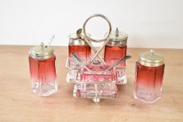 An early 20th-century silver plated and cranberry glass cruet set, with additional salt and pepper