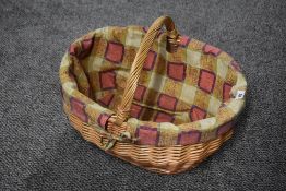 A vintage wicker picnic basket, having a handle and colourful fabric liner, 44cm wide and 35cm
