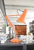 A mid 20th-century orange metal Herbert Terry and Sons Anglepoise model 90 desk lamp, manufactured