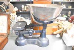 An early to mid 20th-century cast iron counter scales, featuring a removable metal weighing bowl,