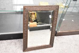 A 19th-century carved hardwood mirror, featuring repeating floral and foliate detailing, unmarked