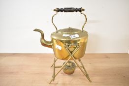 A late 19th to early 20th century brass spirit kettle on a stand with a burner, featuring a turned