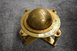A 20th-century brass astrological world globe, mounted on a stand featuring zodiac signs and all