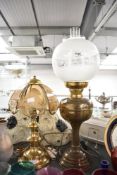 A large Victorian brass and glass converted oil lamp with a frosted and etched glass orb-formed