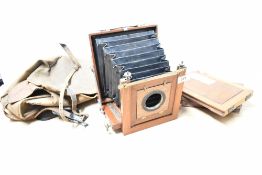 A wooden plate camera, with three plate holders.