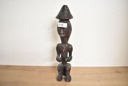 A late 19th to 20th century African Tribal Art hand carved male figural sculpture, featuring a