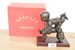 A 20th century Chinese cast and patinated bronze figure group, formed as two young children, the boy