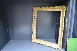 A 20th-century wooden Italian-style ornately carved gilt frame, featuring foliate and scrollwork