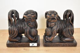 Two early 20th-century carved hardwood Chinese Foo dog book ends, featuring detailed fur