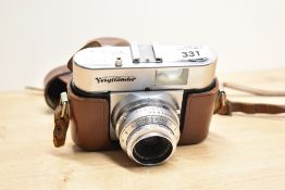 A Voigtlander Vito B camera with Color-Skopar 1:3,5 50mm lens in leather cover. Slight dent just