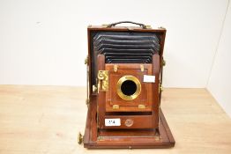 A wooden bellows camera with brass fixings. Engraved on the lens mount 'T T & H', probably referring