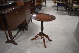 A 19th century style mahogany stem table, having an oval top with moulded pie crust edge over a