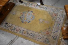 A Chinese yellow ground rug, with central coiled dragon motif within foliate spandrels and
