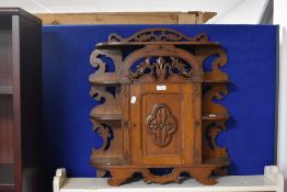 A small 19th century oak free standing cupboard, with arched foliate carved and pierced top rail and