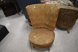 A 1950's upholstered accent chair, the flared and concaved back over a circular sprung seat,