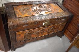 A 20th century heavily carved Chinese camphor wood chest, decorated with carved figural panels