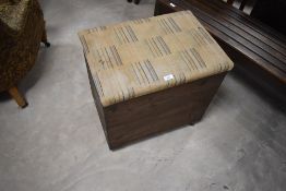 A stained pine box seat, of hinged rectangular form with padded material covered seat, 55cm x 57cm x