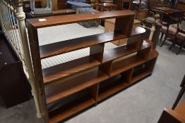 An Art Deco figured mahogany open bookcase, having four graduating or stepped tiers, curved at the