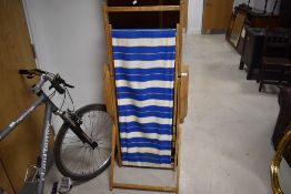 A vintage style wood and material folding deck chair lounger