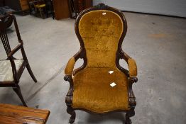 A Victorian stipple carved walnut easy armchair, the deep buttoned spoon form back with foliate
