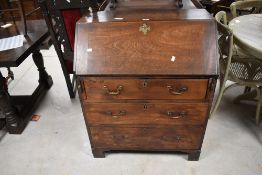 A George III mahogany bureau, of traditional design with hinged fall-front enclosing an