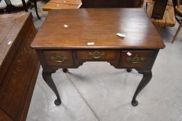 A mahogany lowboy of George III design, having a moulded rectangular top above three drawers and