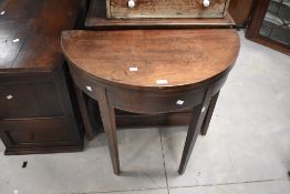 A George III mahogany demi-lune tea table, the hinged top with hinged supports to the rear, all on