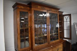 A 19th century figured mahogany break-front secretaire bookcase having a moulded cornice and plain