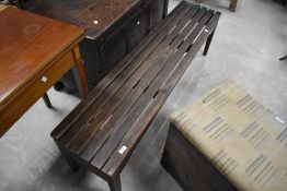 An oblong teak bench, by A Lister & Co, having slatted top and simple tapering square section