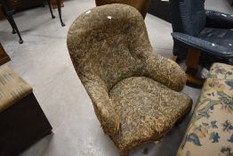 A Victorian buttoned back easy chair, with tub-from back and turned front legs and casters, seat