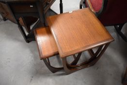 A 1970's G-Plan nest of three tables, of square form with shaped supports, label to underside,