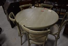 A large modern green stained/painted circular pedestal dining table, and four conforming cane-seated